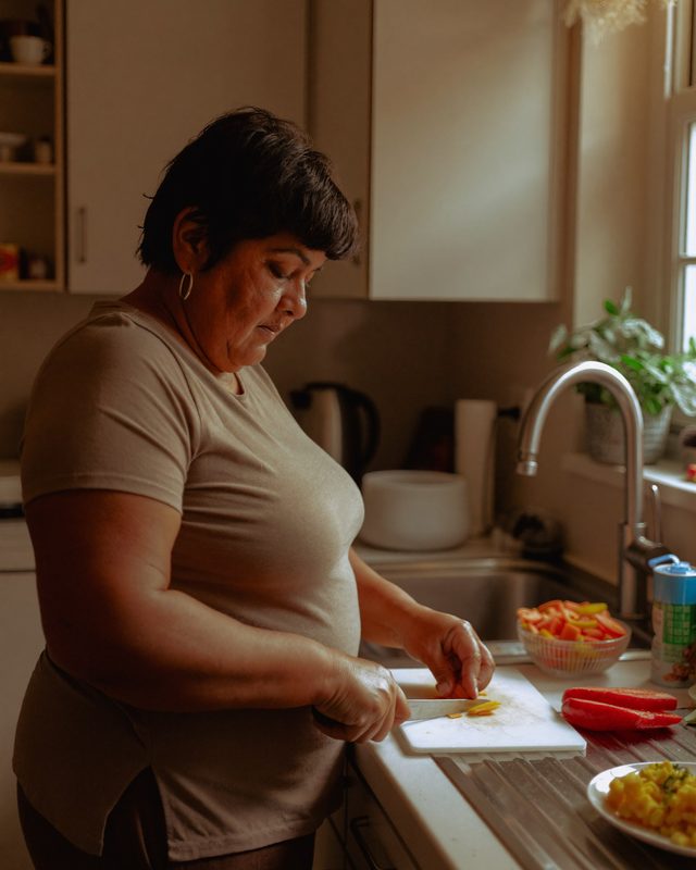 A caregiver tidying and preparing food in a client's kitchen